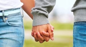 Midsection of a couple holding hands